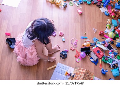 Subang Jaya, Malaysia - August 31, 2018 : Picture Of Little Girl Seating On Wooden Floor With Her Messy Toys.