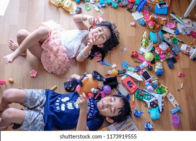 Subang Jaya, Malaysia - August 31, 2018 : Picture of kids laying on wooden floor with their messy toys.