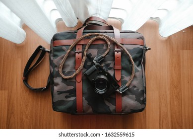 Subang Jaya, Malaysia - February 1,2020: Mirrorless Camera And Messenger Bag On The Wooden Floor From Top View.