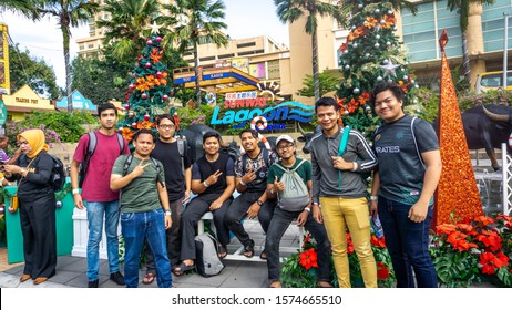 Subang Jaya, Malaysia - November 28, 2019: Group Of Friends Taking Photo At The Entrance To The Sunway Lagoon Water Park And Theme Park. Christmas Season And Concept. Crowd Of People Enter The Gate.