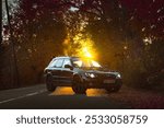 subaru outback on the road with leaves un sunset