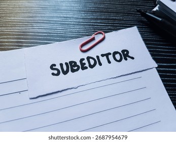 Subeditor writting on table background.