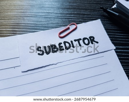 Subeditor writting on table background.