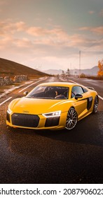 The subject is an orange Audi R8 V10 Plus captured near Edinburgh, UK, in the videogame Forza Horizon 4. The photo was taken on 8 December 2021 during a sunset.