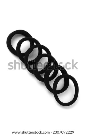 Subject shot of black scrunchies. The set consists of six rubber band. The vogue accessories are isolated on the white background.