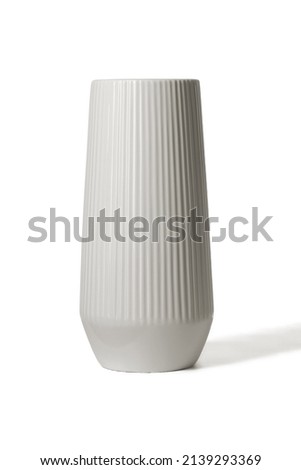 Subject shot of a grey ceramic glossy vase decorated with a glaze. The designer vase with serrated relief surface is isolated on the white background.