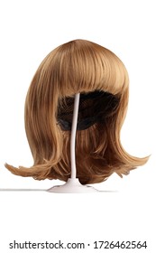 Subject Shot Of A Natural Looking Blonde Wig With Bangs And Twisted Strands Fixed On The White Wigs Holder. The Stand With The Wig Is Isolated On A White Background.  