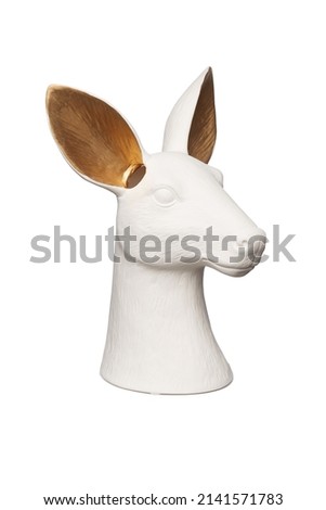 Subject shot of a stylish ceramic matte vase statuette shaped as a deer head. The designer white and gold vase figurine is isolated on the white background.