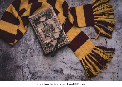 Subjects of the school of magic. Scarf, magic wand, book of spells on grey stone background. 