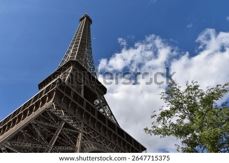 A sublime shot of the Eiffel Tower lit from the left, under a beautiful blue sky.
