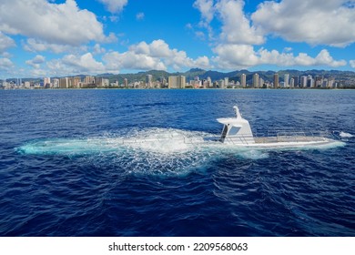 Submarine diving into the waters of the Pacific Ocean offshore Waikiki Beach in Honolulu, Hawaii - Submersible ship taking tourists underwater to explore the ocean floor