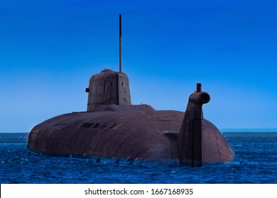 A Submarine Surfaced Above The Water. Part Of The Submarine Peeps Out Of The Sea. Concept - Military Naval Forces. Naval Military Equipment. Submarine On The Background Of Blue Sky. Shipbuilding