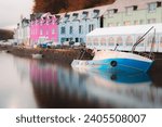 A submerged fishing boat in the harbour at high tide at the colourful seaside village of Portree, Isle of Skye, Scotland, UK in autumn.