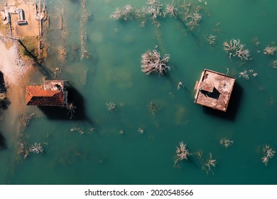 submerged house with tiled roof and dam lake view from above