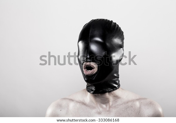 submissive slave with blindfolded eyes in shiny\
rubber mask