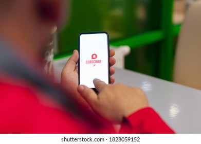 Subscribe to the video channel. Call to action icon on white smartphone screen. The man presses a button on the phone screen - Powered by Shutterstock