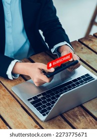 Subscription concept. Red subscribe button with bell icon appear on smart mobile phone in hands. Smartphone horizontal style holding by businesswoman who watching on entertainment applicatiion.