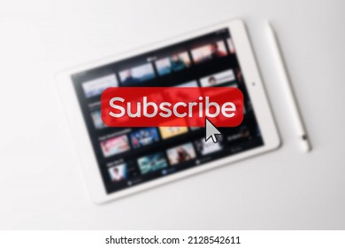 Subscription plan. Red online video subscribe button. Internet service on laptop digital tablet blurred technology background. Visual contents concept. Social networking service