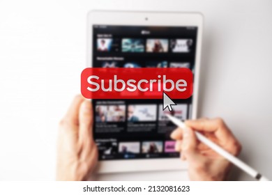 Subscription plan. Red online video subscribe button. Internet service on laptop digital tablet blured technology background. Visual contents concept. Social networking service