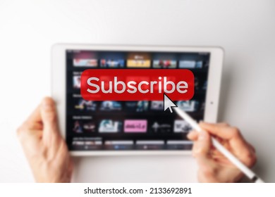 Subscription plan. Red online video subscribe button. Internet service on laptop digital tablet blured technology background. Visual contents concept. Social networking service