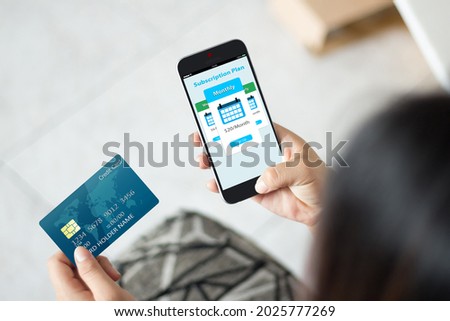 Subscription service business model concepts.Female hands using mobile phone and holding credit card