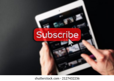 Subscription service. Online video red subscribe button. Internet service on laptop digital tablet blured technology background. Streaming video. Communication network - Powered by Shutterstock