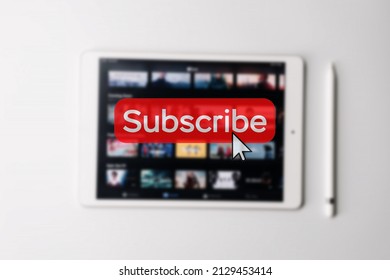 Subscription service. Online video red subscribe button. Internet service on laptop digital tablet blured technology background. Streaming video. Communication network