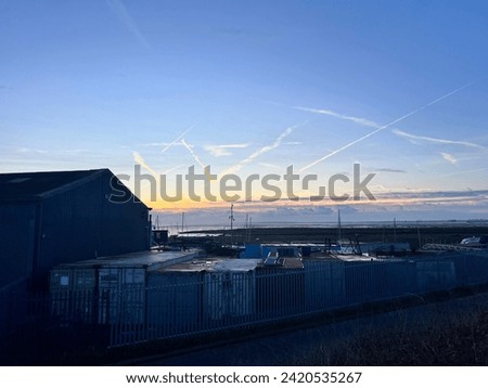 Subset cloud trails over the sea with ship masts