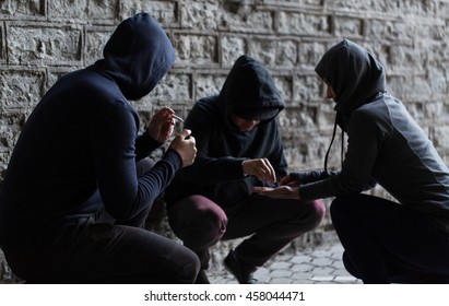 substance abuse, addiction and bad habits concept - close up of young people smoking cigarettes and using drugs outdoors - Shutterstock ID 458044471