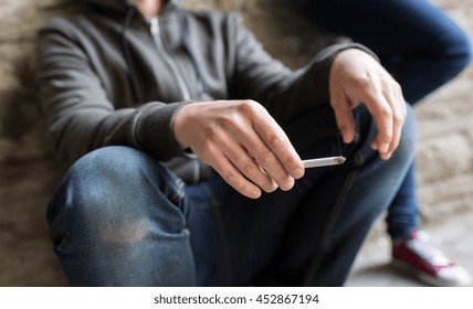substance abuse, addiction, people and bad habits concept - close up of young man smoking cigarette outdoors