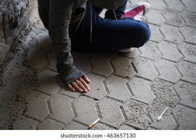 Substance Abuse, Addiction, People And Drug Use Concept - Close Up Of Addict Woman And Used Syringes On Ground