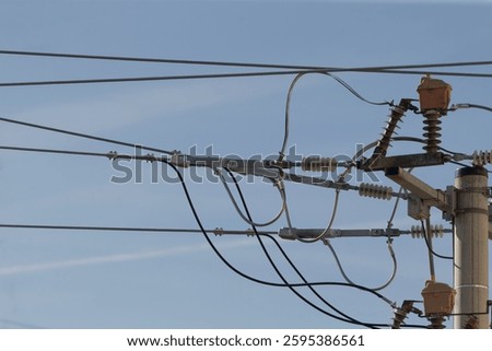 A substantial cluster of power lines is interconnected and linked to a tall utility pole, facilitating the distribution of electricity