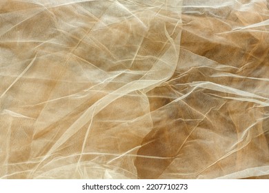 Subtle Background Of Semi-sheer Light Cream Colored Tulle Fabric With A Visible Pattern And Some Wrinkles