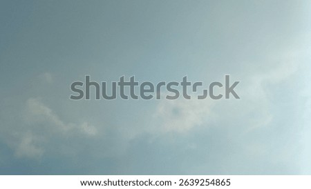 A subtle blue sky with soft, diffuse clouds, creating a calm and expansive background.