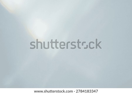 Subtle diagonal light leak and lens flare overlay on pale background