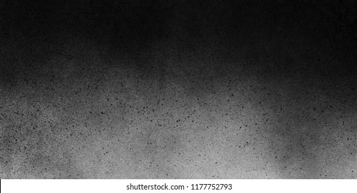 Subtle grain texture. Abstract black and white gritty grunge background. Dark paint spray particles on paper