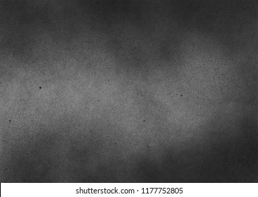 Subtle grain texture. Abstract black and white gritty grunge background. Dark paint spray particles on paper