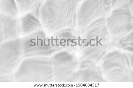 Subtle light shadow image of rippled water texture under the sun. Cool nature flowing water background.
