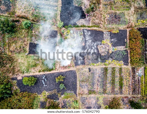 suburb terrain with markings dividing it on\
pieces with smoke, top view, aerial\
photo
