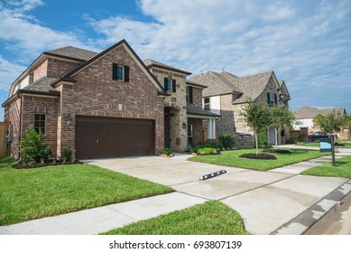 Suburban American neighborhood street with row of brand new two story residential houses in Humble, Texas, US. Newly constructed, freshly built modern home with landscaped yard.