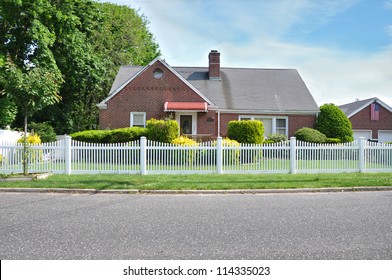 Suburban Brick Home White Picket Fence American Flag Residential Neighborhood Street