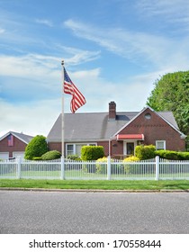 Suburban Brick Home White Picket Fence American Flag