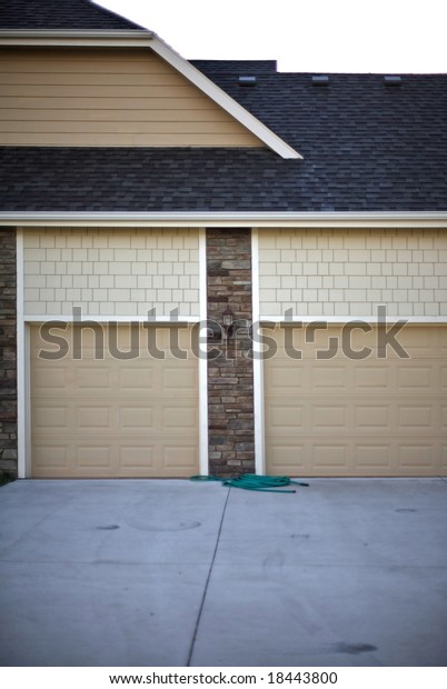 Suburban garage doors\
indicating at least a two car garage typical expectations of a\
\