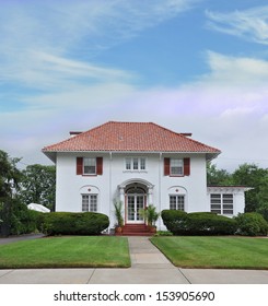 Suburban Georgian Style Home Manicured Front Yard Lawn Blue Sky Clouds USA Residential Neighborhood