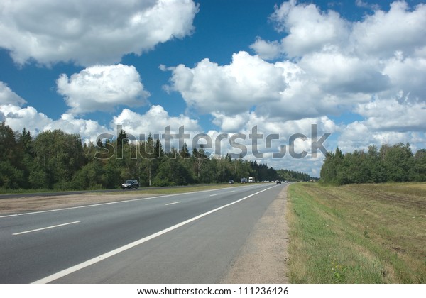 Suburban highway with\
cars in summer day
