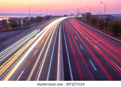 Suburban highway in the evening after sunset. Traces from headlights and taillights of heavy traffic
