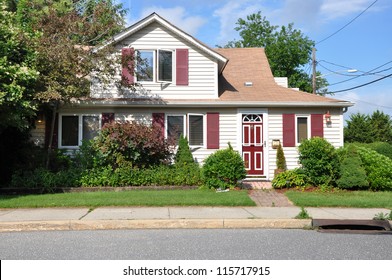 Suburban Home On Middle Class Residential Neighborhood Street With Gutter Sunny Blue Sky Day