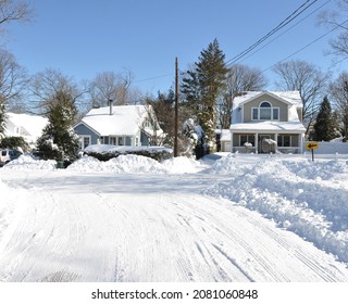 Suburban Homes On Snow Covered Street In Residential Neighborhood After North East USA Winter Storm