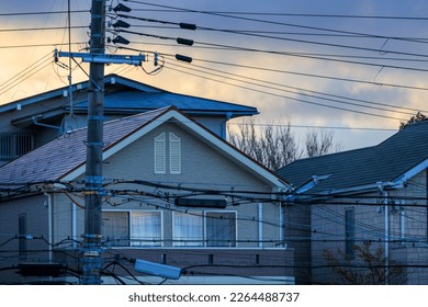 Suburban house with behind web of electrical wires at dawn - Powered by Shutterstock