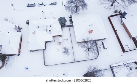 Suburban houses with large backyard and wooden playground under snow cover after historic blizzard storm near Dallas, Texas, USA. Aerial residential home and neighborhood street in winter snow